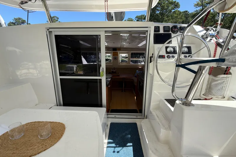 Selah Yacht Photos Pics Leopard 38 catamaran cockpit with steering wheel, sliding door, and outdoor seating area.