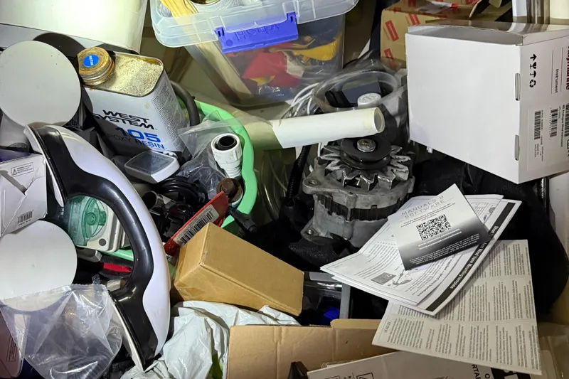 Selah Yacht Photos Pics Cluttered workspace with tools, epoxy resin, and manuals, possibly for Leopard 38 maintenance.