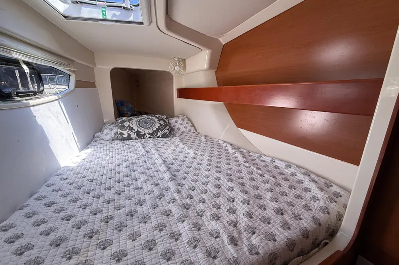 Selah Yacht Photos Pics Cozy cabin interior of 2010 Leopard 38 yacht with patterned bedding and window view.
