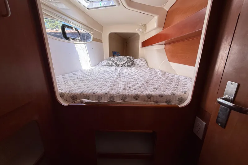 Selah Yacht Photos Pics Cozy cabin interior of 2010 Leopard 38 catamaran with bed and window.