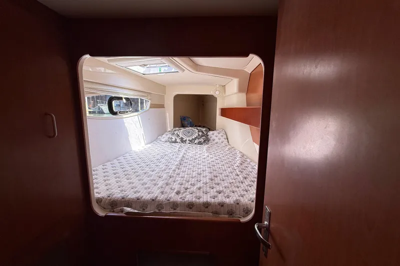 Selah Yacht Photos Pics Cozy bedroom interior of 2010 Leopard 38 yacht with window and patterned bedding.