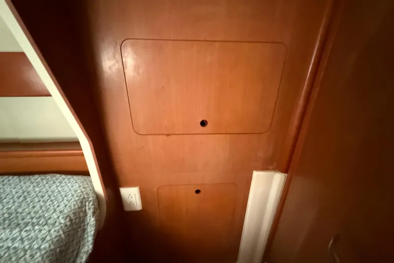 Selah Yacht Photos Pics Wooden interior of a 2010 Leopard 38 yacht, featuring storage compartments and a bed.