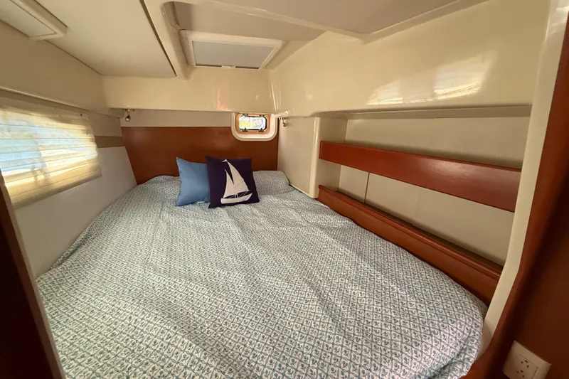 Selah Yacht Photos Pics Cozy cabin interior of 2010 Leopard 38 catamaran with bed and nautical-themed pillows.