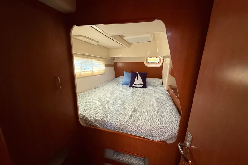 Selah Yacht Photos Pics Cozy cabin interior of 2010 Leopard 38 catamaran with bed and nautical-themed pillows.