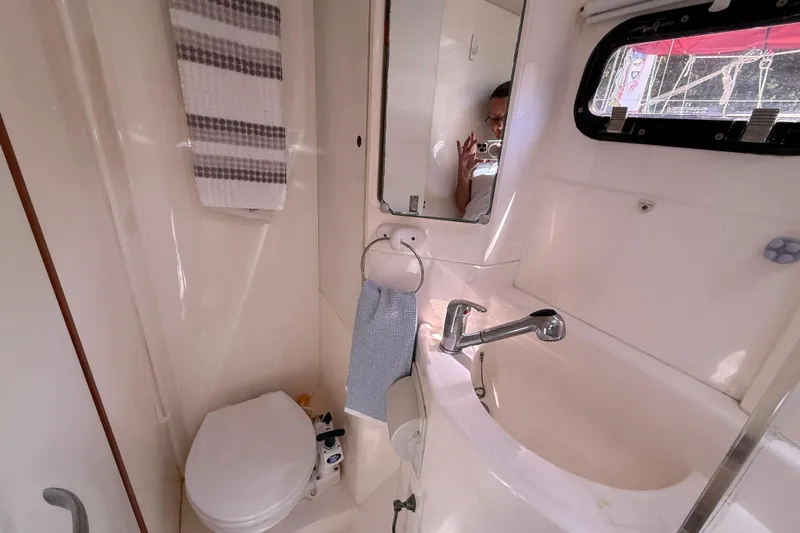 Selah Yacht Photos Pics Compact bathroom in a 2010 Leopard 38 yacht, featuring a sink, toilet, and mirror.