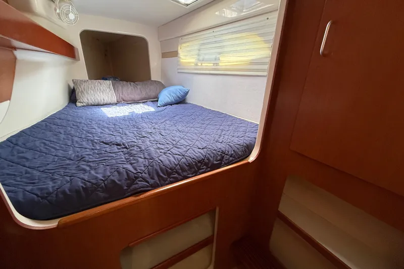 Selah Yacht Photos Pics Cozy cabin interior of 2010 Leopard 38 yacht with blue bedding and wooden accents.