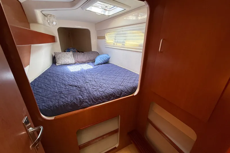 Selah Yacht Photos Pics Cozy cabin interior of 2010 Leopard 38 yacht with bed and wooden finish.