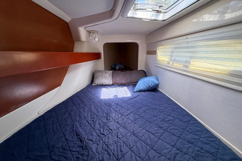 Selah Yacht Photos Pics Cozy cabin interior of 2010 Leopard 38 yacht with blue bedding and skylight.