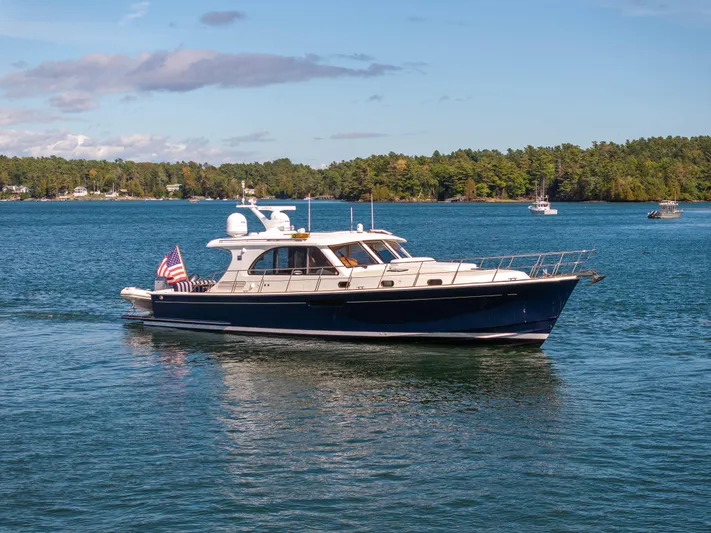 Mystique Yacht Photos Pics 2014 Grand Banks 50 Eastbay SX yacht cruising on a serene lake.