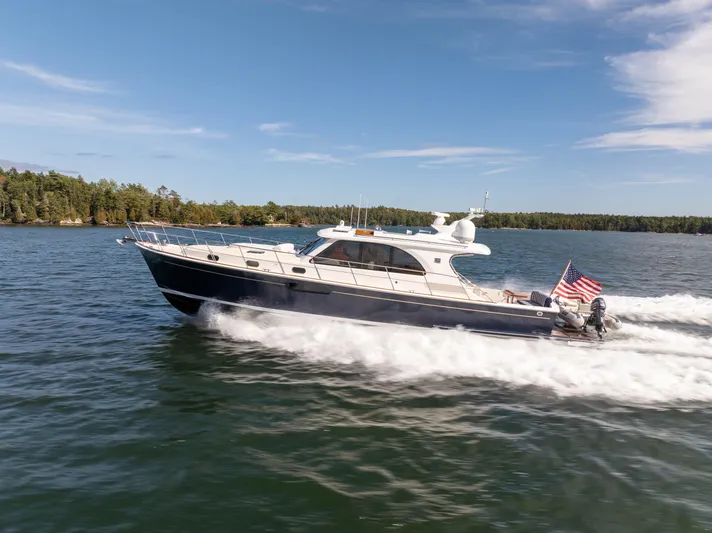 Mystique Yacht Photos Pics 2014 Grand Banks 50 Eastbay SX yacht cruising on a sunny day, American flag displayed.