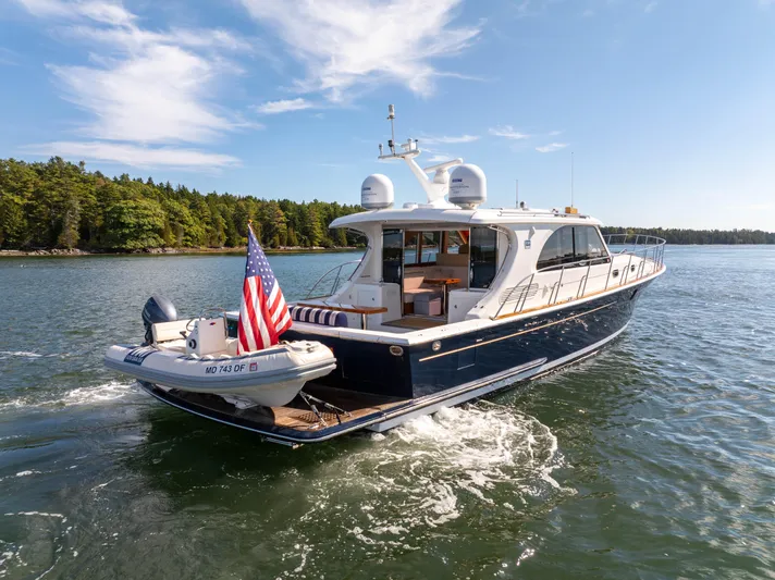 Mystique Yacht Photos Pics 2014 Grand Banks 50 Eastbay SX yacht cruising on a scenic lake with clear skies.