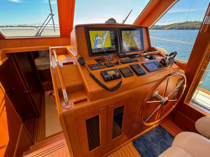 Mystique Yacht Photos Pics Helm of 2014 Grand Banks 50 Eastbay SX yacht with navigation screens and wooden steering wheel.