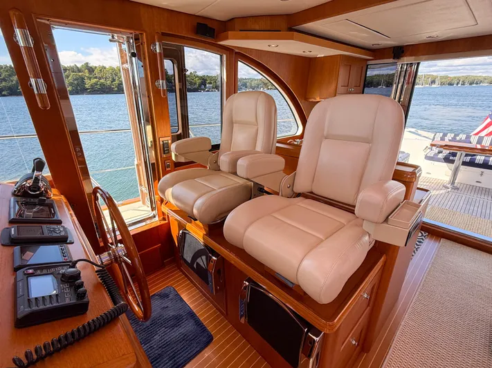 Mystique Yacht Photos Pics Luxurious helm of 2014 Grand Banks 50 Eastbay SX yacht with plush seating and scenic water view.