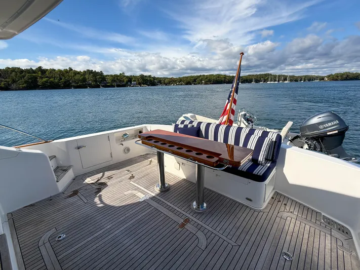 Mystique Yacht Photos Pics 2014 Grand Banks 50 Eastbay SX yacht deck with seating, table, and scenic water view.