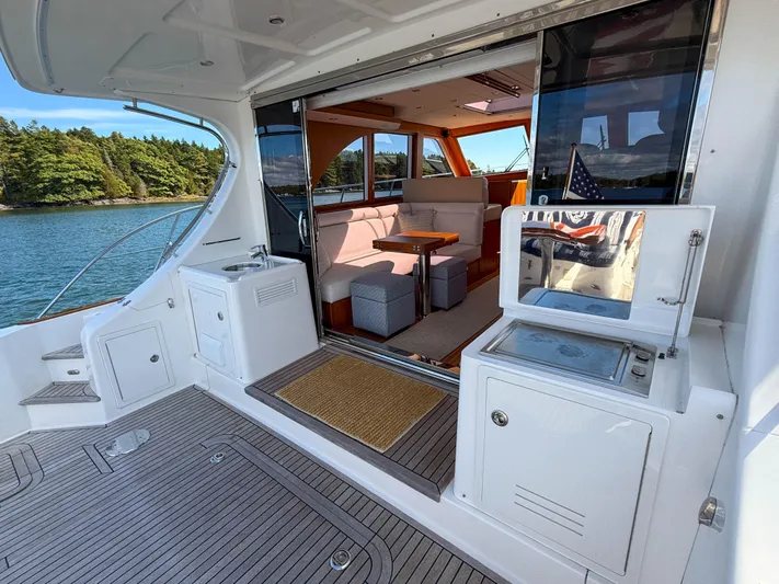 Mystique Yacht Photos Pics 2014 Grand Banks 50 Eastbay SX yacht interior with seating, table, and outdoor view.