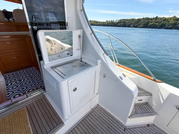 Mystique Yacht Photos Pics 2014 Grand Banks 50 Eastbay SX yacht deck with outdoor sink and scenic water view.