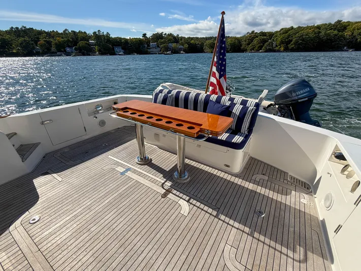 Mystique Yacht Photos Pics 2014 Grand Banks 50 Eastbay SX yacht deck with seating, table, and American flag.