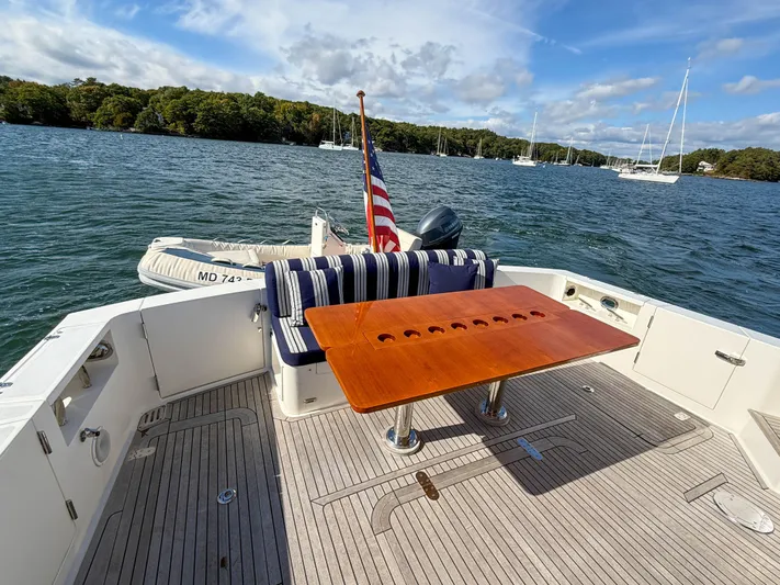 Mystique Yacht Photos Pics 2014 Grand Banks 50 Eastbay SX yacht deck with table, seating, and scenic water view.