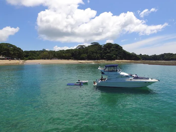  Yacht Photos Pics 2003 Sea Ray 435 yacht anchored in clear turquoise water near a sandy beach.
