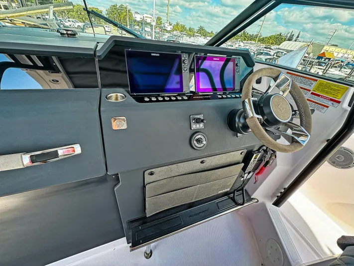  Yacht Photos Pics 2024 Axopar 37 Sun Top helm with dual screens and modern steering wheel.