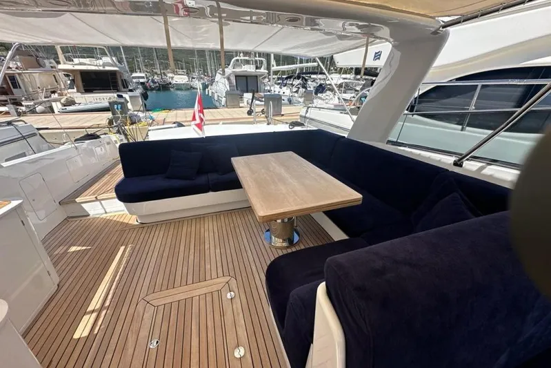  Yacht Photos Pics Luxurious 1987 MAGNUM MARINE 63 yacht deck with elegant seating and wooden table.