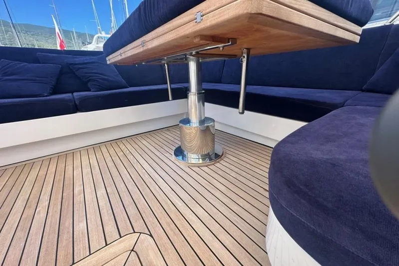  Yacht Photos Pics Luxurious seating area on 1987 MAGNUM MARINE 63 yacht with wooden table and deck.