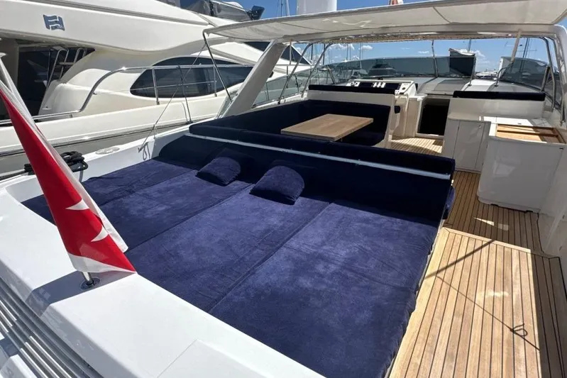  Yacht Photos Pics 1987 MAGNUM MARINE 63 yacht with spacious deck, blue seating, and wooden flooring.