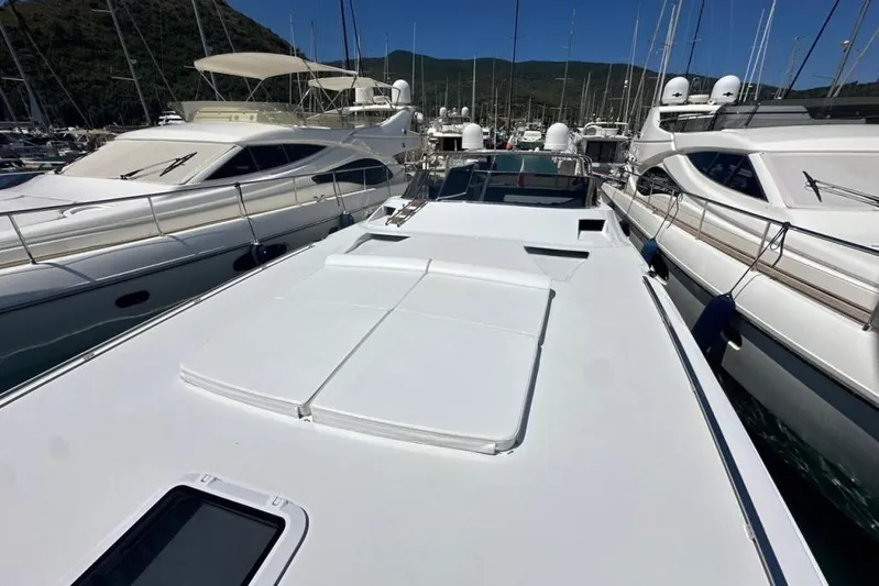  Yacht Photos Pics 1987 MAGNUM MARINE 63 yacht docked among other luxury boats in a marina.