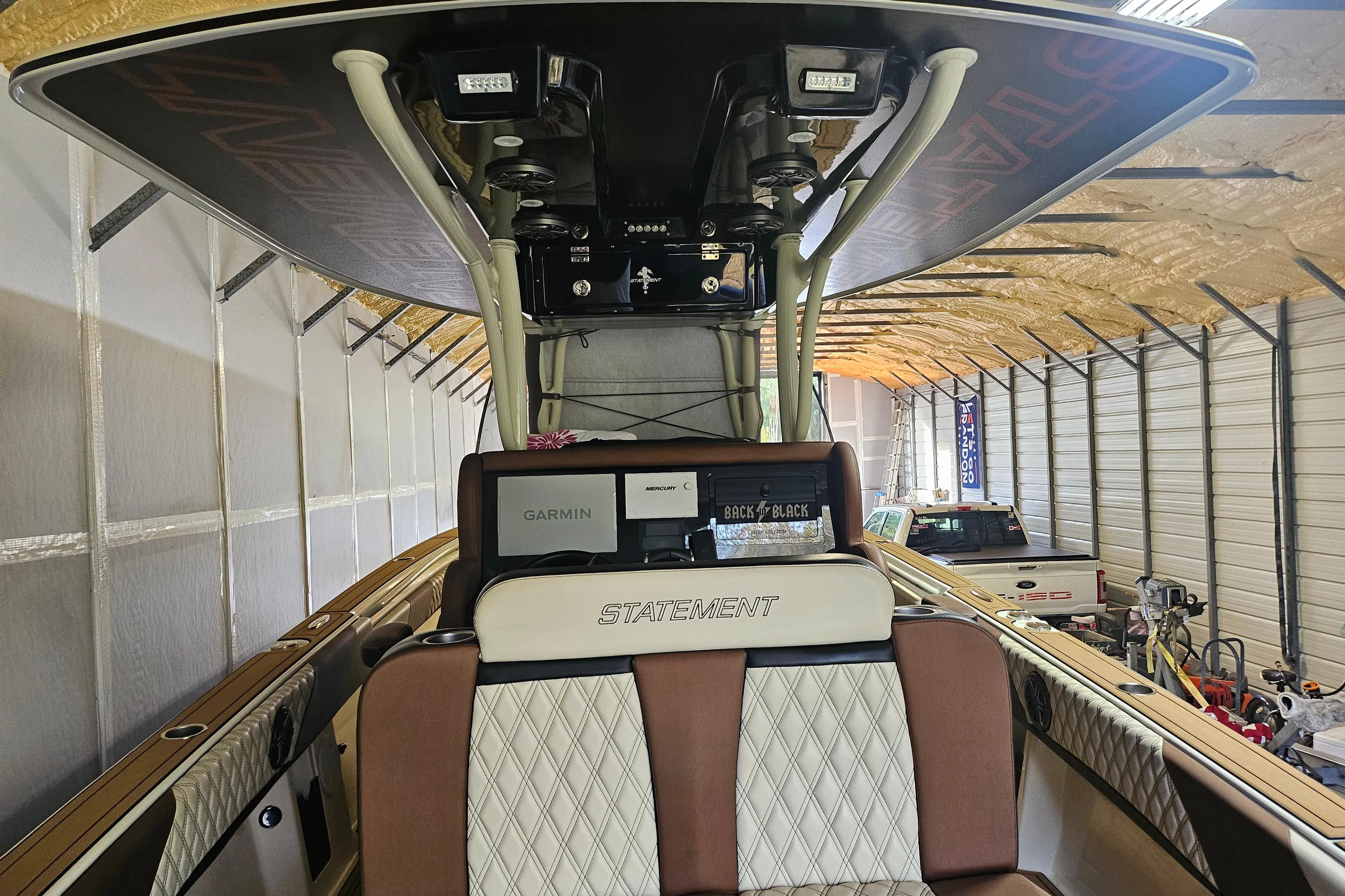2021 Statement 350 Open boat interior with seating and electronics in a storage facility.