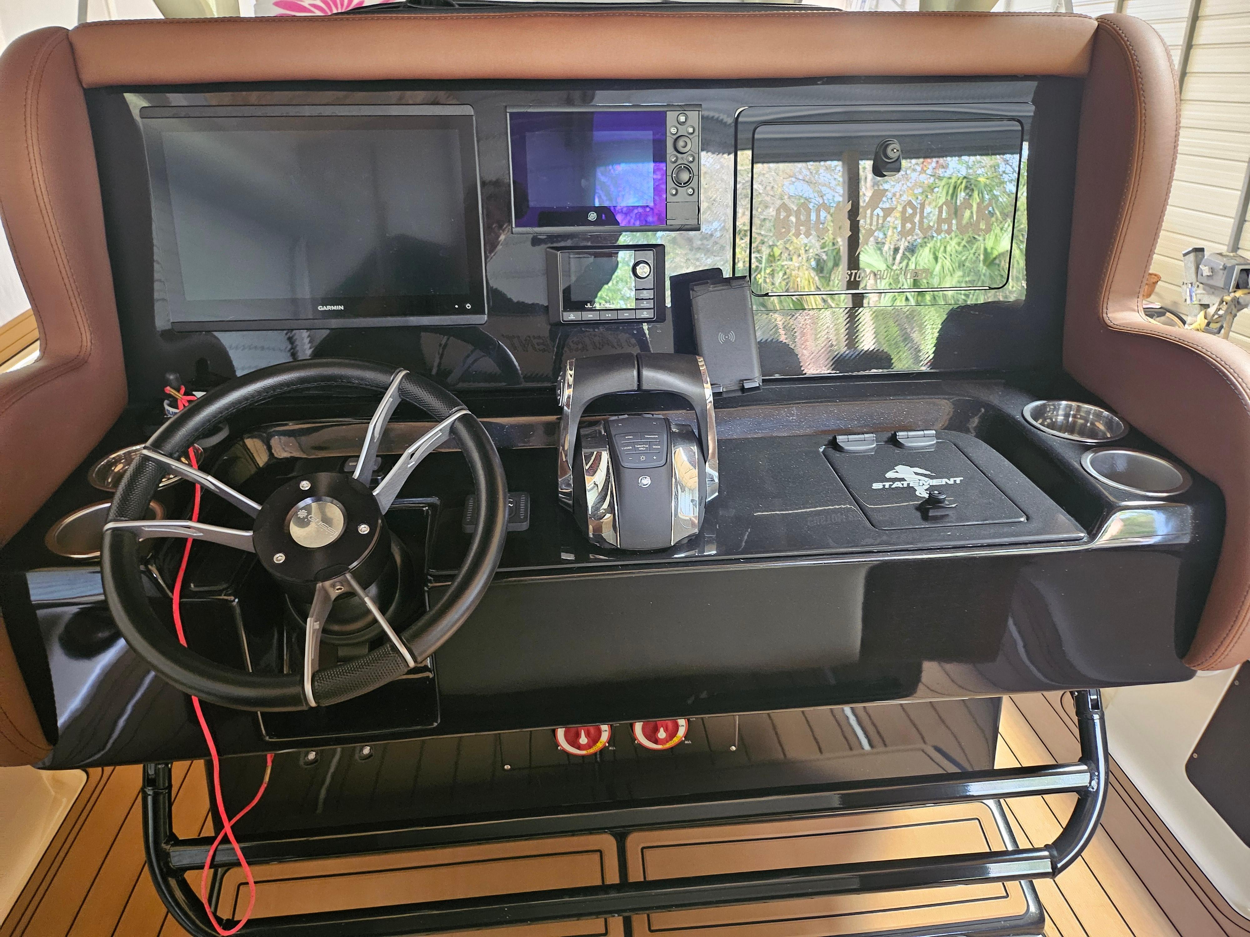 Control panel of 2021 Statement 350 Open boat with steering wheel and navigation screens.