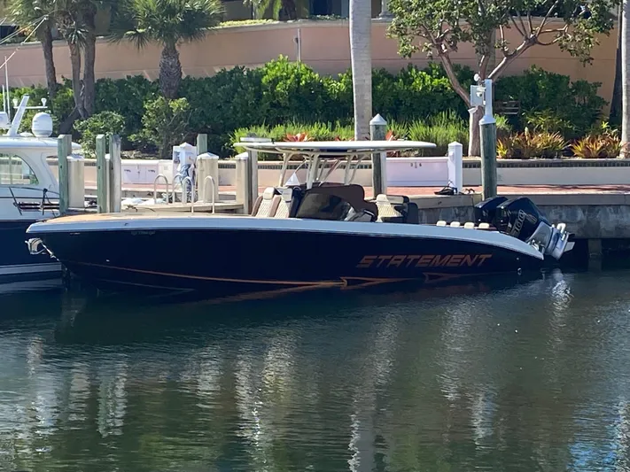  Yacht Photos Pics 2021 Statement 350 Open boat docked by lush greenery and waterfront.