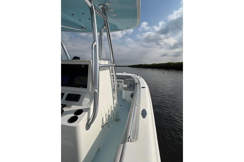  Yacht Photos Pics 2023 Contender 28 Sport boat on calm water under cloudy sky.