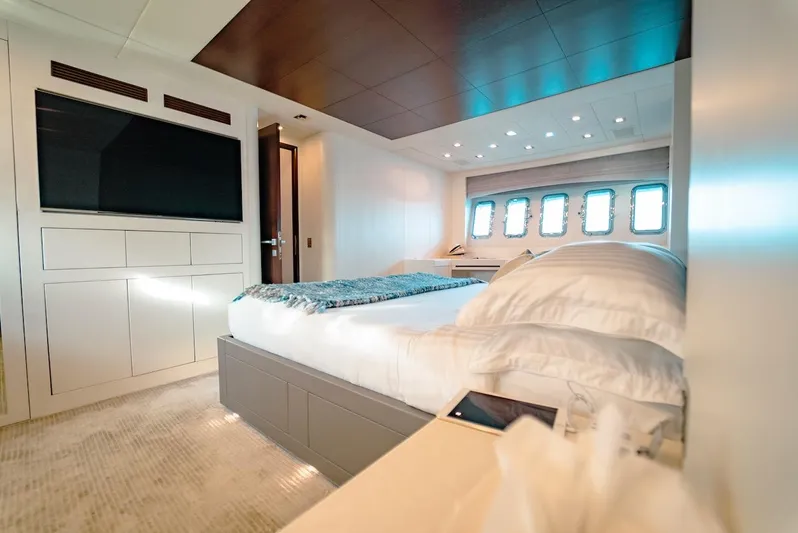 Houdini Yacht Photos Pics Luxurious bedroom interior on 2007 Mangusta 92 yacht with modern design and large windows.