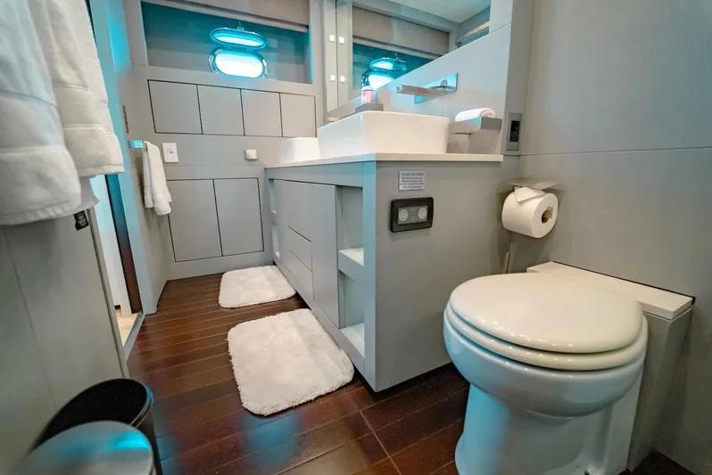 Houdini Yacht Photos Pics Luxurious bathroom in a 2007 Mangusta 92 yacht with modern fixtures and wooden flooring.
