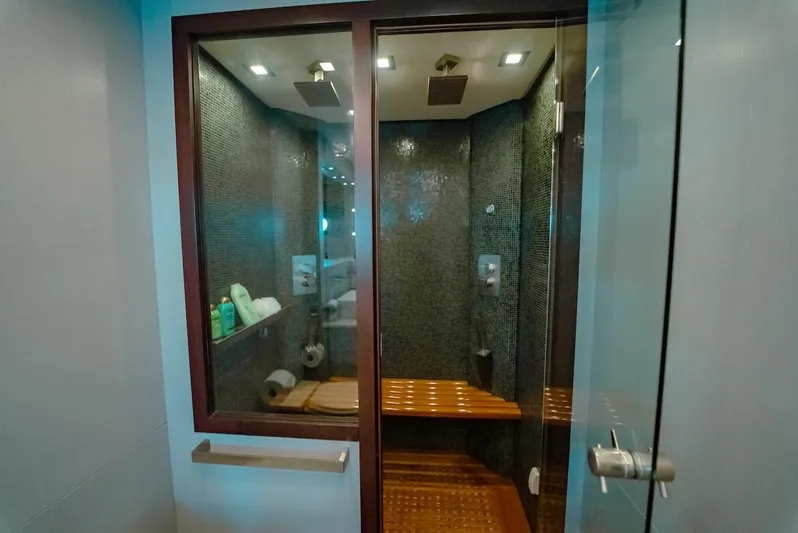 Houdini Yacht Photos Pics Luxurious shower area in a 2007 Mangusta 92 yacht, featuring modern fixtures and wooden seating.