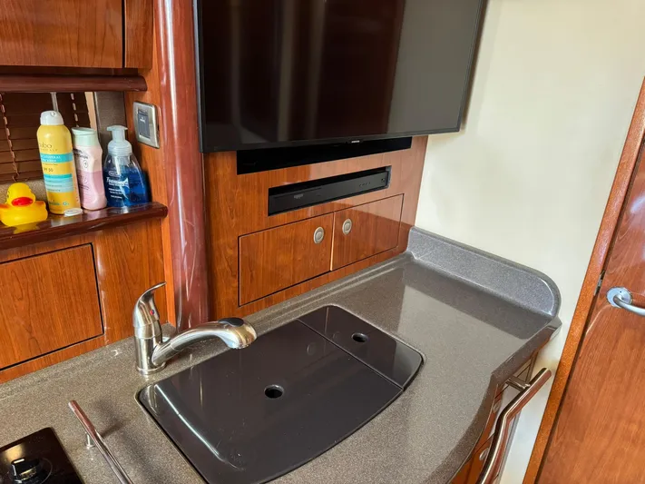  Yacht Photos Pics Interior of 2004 Sea Ray 390 Sundancer with sink, TV, and wooden cabinetry.