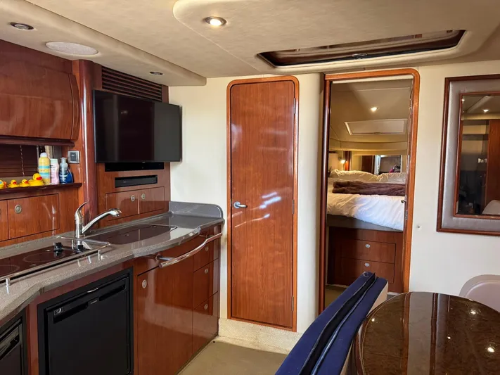  Yacht Photos Pics Luxurious interior of 2004 Sea Ray 390 Sundancer yacht with kitchenette and cozy bedroom.