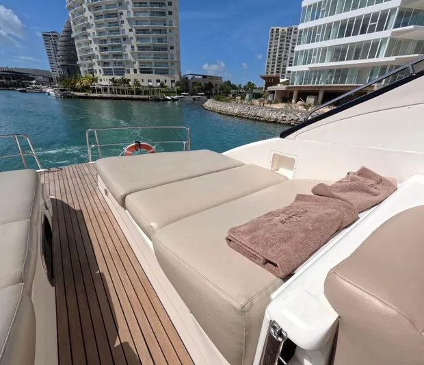 Incentive Yacht Photos Pics Luxury yacht deck with sun loungers, overlooking marina and modern buildings. Princess 65, 2004 model.
