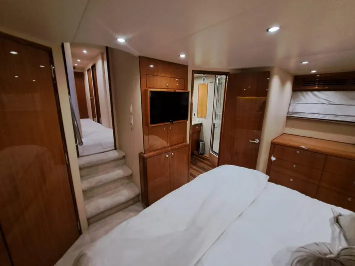 Mary Rose Yacht Photos Pics Luxurious bedroom interior of 2006 Hatteras 68 Convertible yacht with wood finishes and modern amenities.