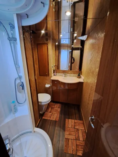 Mary Rose Yacht Photos Pics Luxurious bathroom in 2006 Hatteras 68 Convertible yacht with modern fixtures and wood accents.