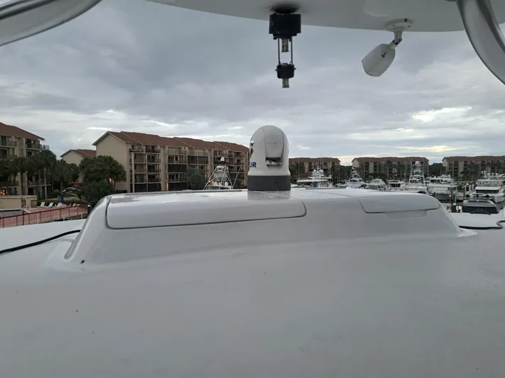 Mary Rose Yacht Photos Pics 2006 Hatteras 68 Convertible yacht with marina and buildings in the background.