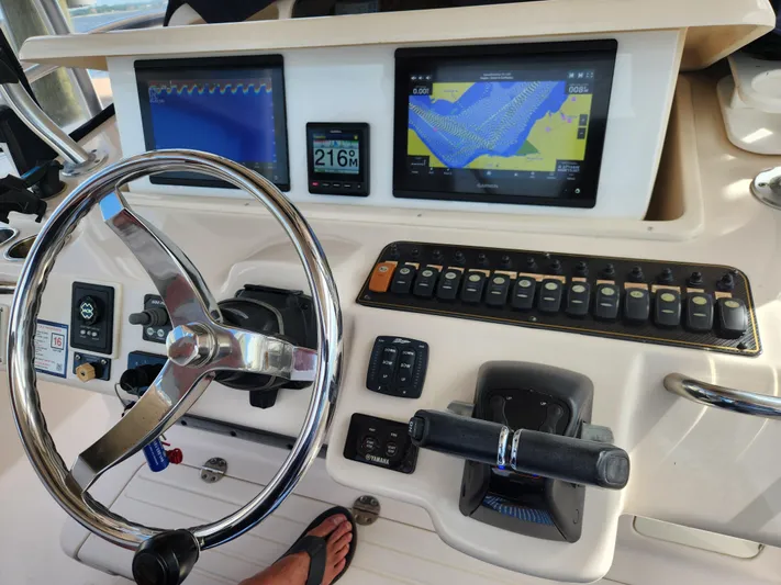  Yacht Photos Pics Control panel of 2012 Grady-White Canyon 336 boat with navigation screens and steering wheel.