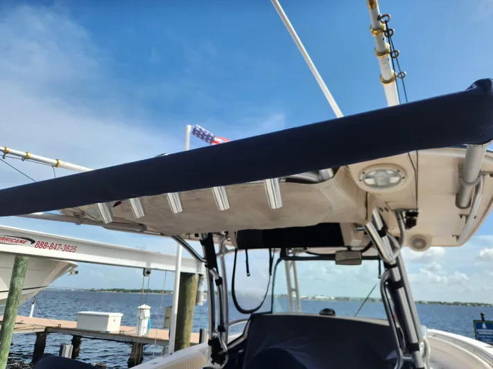  Yacht Photos Pics 2012 Grady-White Canyon 336 boat docked, featuring fishing rod holders and canopy, under clear sky.