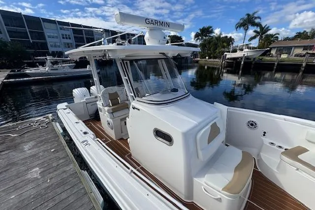  Yacht Photos Pics 2022 Edgewater 280CC boat docked, featuring Garmin equipment, sleek design, and spacious seating.