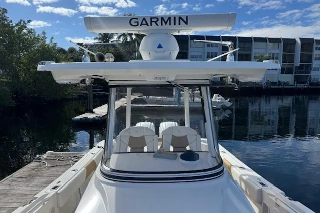  Yacht Photos Pics 2022 Edgewater 280CC boat docked, featuring Garmin radar, clear skies, and waterfront buildings.