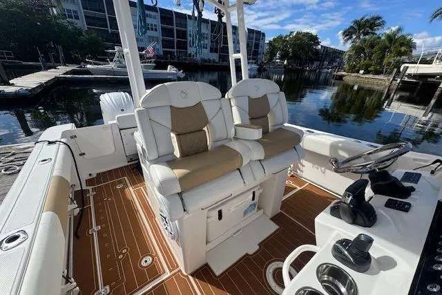  Yacht Photos Pics 2022 Edgewater 280CC boat interior with dual seats and modern controls, docked by waterfront.