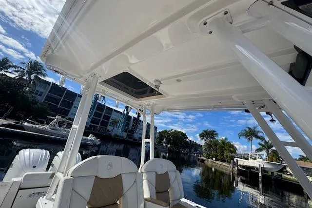  Yacht Photos Pics 2022 Edgewater 280CC boat interior with seating, docked near waterfront homes.
