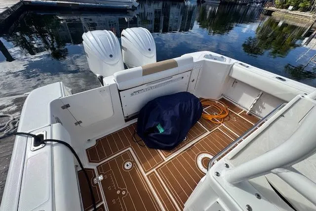  Yacht Photos Pics 2022 Edgewater 280CC boat interior with twin engines, docked by calm water.