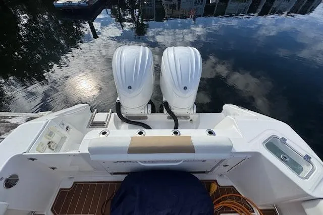 Yacht Photos Pics 2022 Edgewater 280CC boat with dual engines, docked on calm water.