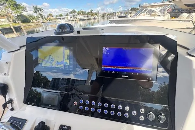  Yacht Photos Pics Edgewater 280CC 2022 boat dashboard with navigation and sonar displays in a marina setting.
